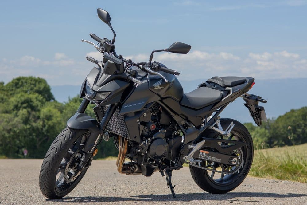 Moto preta estacionada numa estrada sob o céu azul